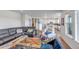 Bright, open-concept living room flows into kitchen, with contemporary furnishings and colorful rug at 8255 S Vandriver Way, Aurora, CO 80016
