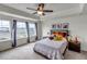 Cozy main bedroom with tray ceiling, large windows, and decorative throw pillows at 8255 S Vandriver Way, Aurora, CO 80016