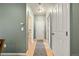 Hallway with wood floors and neutral paint, and a door leading to a bathroom at 9622 W Coco Cir # 203, Littleton, CO 80128