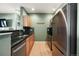 Galley style kitchen boasts stainless steel appliances, wood cabinets, and modern backsplash at 9622 W Coco Cir # 203, Littleton, CO 80128