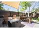 Outdoor patio seating area has a shade awning, fire pit, and landscaping at 1718 W 33Rd Ave, Denver, CO 80211