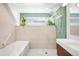 Modern bathroom with a separate shower stall and tub, featuring green accent tiles and unique plant decor at 1718 W 33Rd Ave, Denver, CO 80211