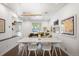 Bright dining room with white table and chairs, dark floors, and modern art at 1718 W 33Rd Ave, Denver, CO 80211