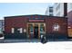 Quaint brewery with wood and white exterior, a fenced patio, and clear storefront windows at 1718 W 33Rd Ave, Denver, CO 80211