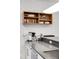 Modern kitchen features a bar countertop, light wood shelving, and brick accent wall at 1718 W 33Rd Ave, Denver, CO 80211