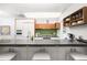 Modern kitchen featuring sleek gray countertops, white and wood cabinets, and green tiled backsplash at 1718 W 33Rd Ave, Denver, CO 80211