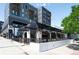 Street level angle of a trendy restaurant with white brick, black metal awnings and railings, and glass windows at 1718 W 33Rd Ave, Denver, CO 80211