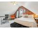 Bright attic bedroom with exposed brick, cozy seating, and functional workspace at 953 Kalamath St, Denver, CO 80204