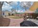 Landscaped backyard with a stone patio, outdoor dining set, grill, and shade sail at 953 Kalamath St, Denver, CO 80204