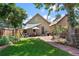 A serene backyard featuring a stone patio, mature trees, and privacy fencing, perfect for outdoor entertaining and relaxing at 953 Kalamath St, Denver, CO 80204