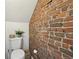 Cozy bathroom featuring exposed brick wall and toilet with decorative accents at 953 Kalamath St, Denver, CO 80204