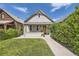 Charming home featuring a quaint front porch, well-manicured lawn, and inviting curb appeal on a sunny day at 953 Kalamath St, Denver, CO 80204