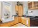 Bright kitchen features wood cabinets, a cozy window nook, and modern black appliances at 953 Kalamath St, Denver, CO 80204