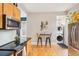 Efficient kitchen with stainless steel appliances, warm wood cabinets and adjacent laundry area at 953 Kalamath St, Denver, CO 80204