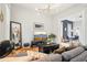 Cozy living room showcasing a gray sectional, modern light fixture, and an open flow into dining area at 953 Kalamath St, Denver, CO 80204