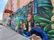 Detailed mural on a brick building, depicting cultural figures and symbolic imagery with vibrant colors and textures at 953 Kalamath St, Denver, CO 80204