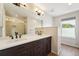 Bathroom features double sinks, dark wood cabinets, stone countertop and glass shower at 2120 Pintail Dr, Longmont, CO 80504