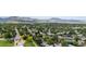 Expansive aerial view showcasing a residential area with mature trees, a park, and scenic mountain views at 12277 W Chenango Dr, Morrison, CO 80465