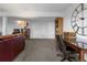Basement with neutral carpet, large wall clock, and a brown leather couch at 12277 W Chenango Dr, Morrison, CO 80465