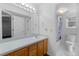 Bright bathroom featuring a large mirror, vanity with storage, and a combined tub and shower, blending functionality with style at 12277 W Chenango Dr, Morrison, CO 80465