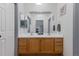 Bathroom with double sinks, wood cabinets, and an oversized mirror at 12277 W Chenango Dr, Morrison, CO 80465