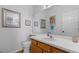 Clean half-bath with wood cabinets and decorated with wall art at 12277 W Chenango Dr, Morrison, CO 80465
