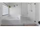 Bright bathroom with a soaking tub, shower, and patterned glass block window at 12277 W Chenango Dr, Morrison, CO 80465