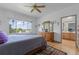 Bright bedroom featuring a dresser, a ceiling fan, hardwood floors, and an ensuite bathroom at 12277 W Chenango Dr, Morrison, CO 80465