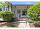 Inviting front porch with decorative columns, a security system sign, and landscaped flower beds at 12277 W Chenango Dr, Morrison, CO 80465