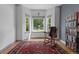 Relaxing living room with natural light, a vintage rocking chair, and an eye-catching red Persian-style rug at 12277 W Chenango Dr, Morrison, CO 80465