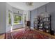 Cozy living room featuring large windows with natural light, a rocking chair, and a full bookcase at 12277 W Chenango Dr, Morrison, CO 80465