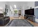 Bright, open living room featuring hardwood floors, a neutral color scheme, and modern entertainment center at 12277 W Chenango Dr, Morrison, CO 80465
