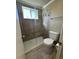 Bathroom features a glass-door shower, updated tile, a modern showerhead and toilet at 8828 E Florida # 113, Denver, CO 80247