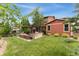 Backyard with lush lawn and patio with an outdoor kitchen, pergola, and lounge seating area at 21962 E Idyllwilde Dr, Parker, CO 80138