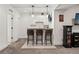 Basement bar with white cabinets, bar stools and adjacent entertainment area enhance the home's appeal at 21962 E Idyllwilde Dr, Parker, CO 80138