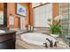Bright bathroom features soaking tub, dark vanity and fixtures and a shower behind glass at 21962 E Idyllwilde Dr, Parker, CO 80138