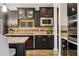 Elegant kitchen with dark wood cabinetry, tile backsplash, and modern appliances at 21962 E Idyllwilde Dr, Parker, CO 80138