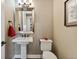Stylish powder room with pedestal sink, decorative mirror, and neutral tones at 21962 E Idyllwilde Dr, Parker, CO 80138