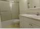 Compact bathroom with marble vanity, combination tub and shower, and all-white finishes at 580 S Clinton St # 10D, Denver, CO 80247
