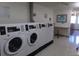 Clean laundry room with multiple washing machines at 580 S Clinton St # 10D, Denver, CO 80247