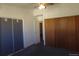 A basic bedroom with carpeted floor, fan, and view of closet and bathroom through doorways at 580 S Clinton St # 10D, Denver, CO 80247