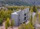 Contemporary gray home with large windows surrounded by lush evergreen trees and natural landscape at 10354 Georgia Cir, Morrison, CO 80465