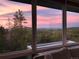 Inviting living room with expansive windows showcasing a beautiful sunset and views of trees at 10354 Georgia Cir, Morrison, CO 80465