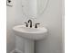 A compact pedestal sink with a dark faucet and an oval mirror at 9253 Truckee Ct, Commerce City, CO 80022