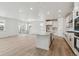 Open floor plan featuring a large kitchen island with white cabinetry and modern stainless steel appliances at 9253 Truckee Ct, Commerce City, CO 80022