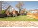 Large, fenced backyard with green lawn, mature trees, and a detached brick garage at 3905 Tejon St, Denver, CO 80211