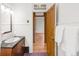 A bathroom with a wood vanity, dark countertop and hardwood floors beyond the doorway at 3905 Tejon St, Denver, CO 80211
