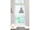 Close up on modern lighting over the dining room table, next to a window with tree views at 3905 Tejon St, Denver, CO 80211