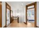 Well-lit hallway with hardwood floors and decorative doorways leading to various rooms in the home at 3905 Tejon St, Denver, CO 80211