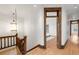 Upper hallway featuring hardwood floors, decorative lighting, and wood trim leading to the bedroom at 3905 Tejon St, Denver, CO 80211